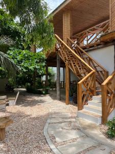 a house with a wooden staircase in a yard at Meat and Mingle Tavern in Paje