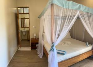 a bedroom with a bed with a canopy at Meat and Mingle Tavern in Paje +12 photos