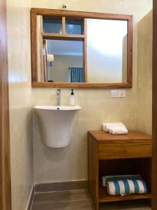 a bathroom with a sink and a mirror at Meat and Mingle Tavern in Paje