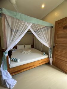 a bedroom with a bed with a canopy at Meat and Mingle Tavern in Paje