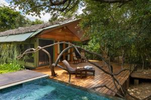 a small house with a swing and a swimming pool at AARAWILD Luxury Villas - Sigiriya in Sigiriya