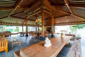 a large pavilion with wooden tables and chairs and tables at Villa 234 Yogyakarta in Yogyakarta