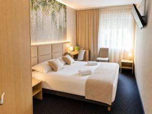 ein Hotelzimmer mit einem großen Bett und einem Fenster in der Unterkunft Great Polonia Silesian Quality Hotel in Kattowitz