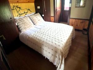 a bedroom with a bed with a white comforter at Relais Équestre du Neufeld - Roulotte Nature in Oberhaslach