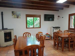 a dining room with a table and chairs and a fireplace at Albergue Casa Txakainlo in Lesaka