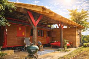 a house with awning and a grill on a patio at Relais Équestre du Neufeld - Roulotte Nature in Oberhaslach +18 photos