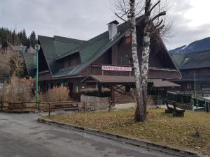 een groot gebouw met een boom ervoor bij Appartamento Camporosso in Tarvisio