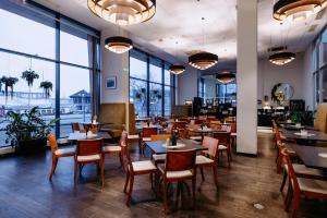 ein Restaurant mit Tischen und Stühlen und großen Fenstern in der Unterkunft Hestia Hotel Europa in Tallinn
