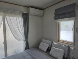 a bedroom with a bed and a window at フルハウス in Fujikawaguchiko
