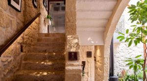 a staircase in a house with stone walls at The Mdina Heritage Boutique Hotel - By Luxury Villas International in Rabat +120 photos