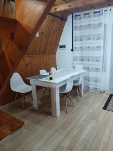a dining room with a white table and chairs at Domek nad jeziorem in Jagodne