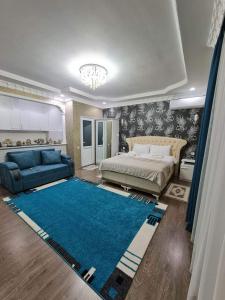 a bedroom with a bed and a blue rug at Hotel Tabidze in Batumi