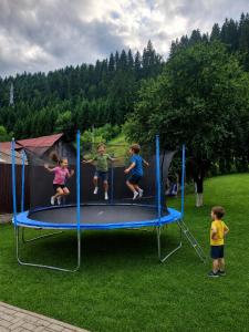 a group of children jumping on a trampoline at Căsuța Piticilor in Broşteni
