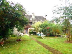 a house with two chairs and a table in the yard at Air de Monade in Oloron-Sainte-Marie