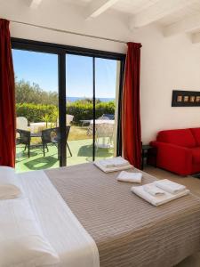 a bedroom with a bed and a red couch at Natur Hotel Tanca in Cardedu