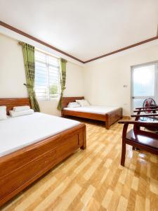 a bedroom with two beds and a desk in it at Hồng Thu Hotel Cao Bằng in Cao Bằng
