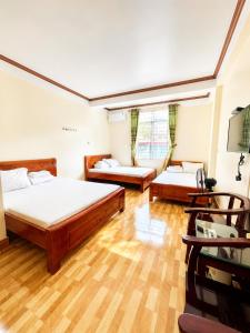 two beds in a room with wooden floors at Hồng Thu Hotel Cao Bằng in Cao Bằng +42 photos