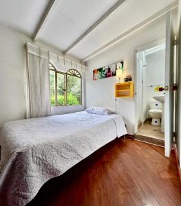 a bedroom with a bed and a bathroom with a sink at Hotel Casa Iris in Chía +30 photos
