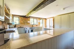 a large kitchen with white cabinets and a counter top at Bowden Lodge in Deal