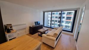 a living room with a couch and a large window at Luxury and Morden Deux & Furry Friends welcome in Auckland