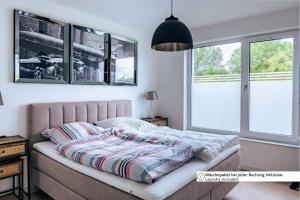 a bed in a bedroom with two windows at Zweite Heimat Apartment 2 in Lohme