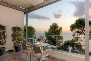 a patio with a table and chairs and a view of the ocean at Galetso Studios by Still Collection in Nikiti