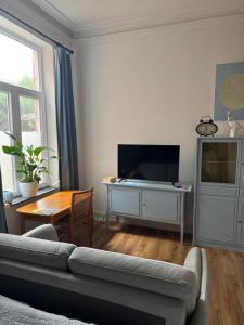 a living room with a couch and a flat screen tv at Elfenvilla in Erkelenz