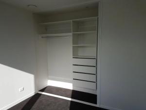 a walk in closet with white walls and shelves at Luxury and Morden Deux & Furry Friends welcome in Auckland