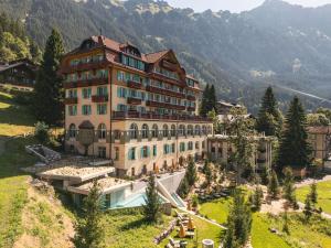 a large building on a hill with a pool at Grand Hotel Belvedere, a Beaumier Hotel in Wengen