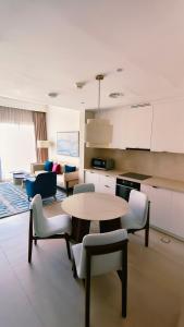 a kitchen and living room with a table and chairs at Apartment at Vida Marina Marassi, North Coast in El Alamein