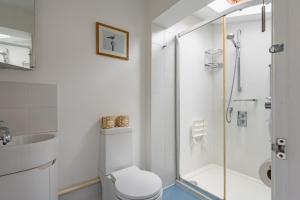 a bathroom with a shower and a toilet and a sink at Captains Cottage in Deal