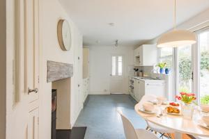 a white kitchen with a table and chairs at Captains Cottage in Deal +23 photos