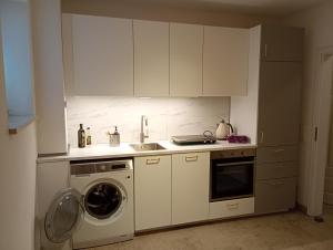 a kitchen with white cabinets and a washing machine at Cottage Living 2 in Leiblfing