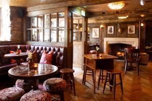 a restaurant with tables and chairs and a fireplace at The Unicorn, Ambleside in Ambleside