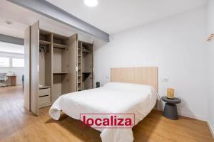 a bedroom with a large white bed and a desk at Amplio y moderno apartamento in Almería