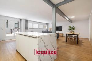 a kitchen and living room with a marble counter top at Amplio y moderno apartamento in Almería