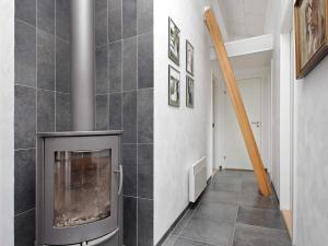 a fireplace in a living room with a tile wall at 5 star holiday home in Brovst in Brovst