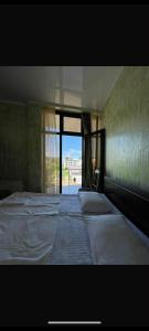 a bedroom with two beds and a large window at Rusalka in Kobuleti