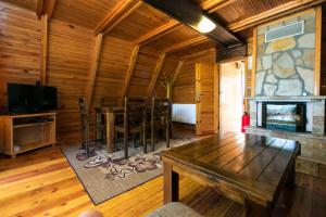 ein Wohnzimmer mit einem Tisch und einem Kamin in der Unterkunft Romantica Forest Guest House in Dospat