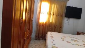 a bedroom with a bed and a window and a television at Penthouse Sea Apartment in El Mîna +63 photos