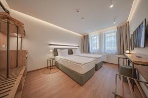 a hotel room with a bed and a desk and window at Aparthotel SamElyon in Samokov