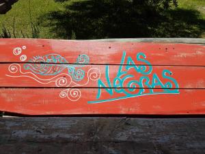 un banco rojo con graffiti en la parte trasera en Las Negras en Punta del Diablo