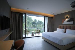 a bedroom with a large bed and a balcony at Better Suites Hotel in Meppādi
