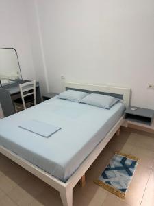 a large bed in a room with a desk at Vila 3 palmat in Ksamil