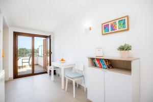 a white room with a table and chairs and a window at Cala Figuera Studio 5b in Cala Figuera