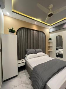 a bedroom with a large bed with a large headboard at Travellers Heaven in Karachi