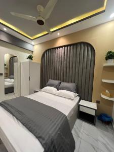 a bedroom with a large bed with a black headboard at Travellers Heaven in Karachi
