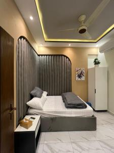 a bedroom with a bed with a large headboard at Travellers Heaven in Karachi