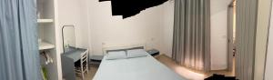 a small bedroom with a white bed and a mirror at Vila 3 palmat in Ksamil