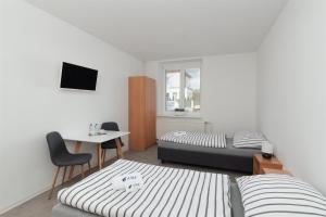 a living room with two beds and a table and a desk at Ubytování AMZ in Vrábí